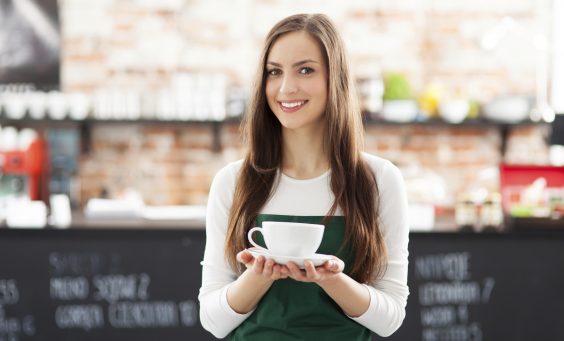 Waitress holding cup of coffee in cafe